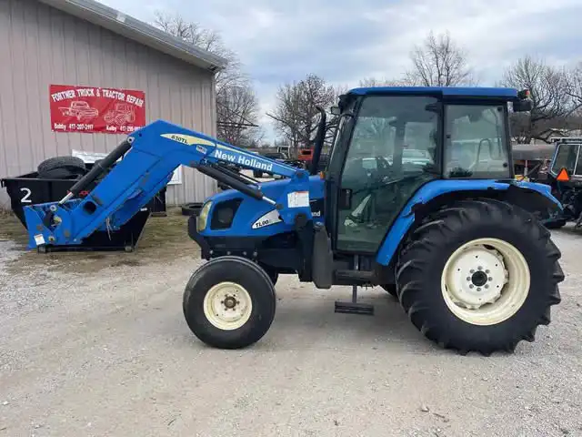 a blue tractor with a backhoe